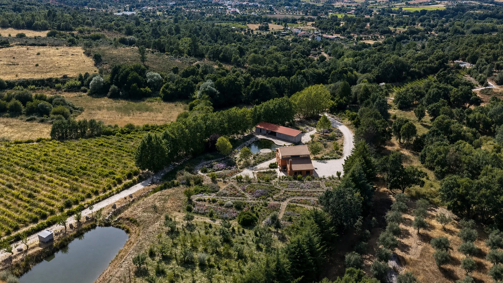 Aerial view of The Elysian Gardens — vineyard, ponds and earthen villas in Aldeia Nova do Cabo, Fundão
